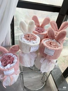 four hats with flowers and bunny ears on display in front of a window, one for the head