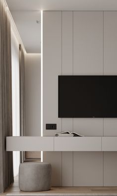 a flat screen tv mounted to the side of a white wall in a living room