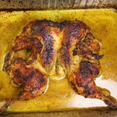 a cooked chicken sitting on top of a pan covered in oil