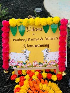 a welcome sign is surrounded by flowers and other decorations in front of the entrance to prathep ramya & athar's housewarming