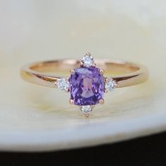 "This Engagement ring features a Purple sapphire in cushion cut. The sapphire is natural, eye clean and sparkling. It is set in a 5-stone setting flanked by 4 diamonds. This ring would make a perfect engagement ring, anniversary ring or promise ring. The setting is 14k Rose gold, diamonds SI/H. Details: Center stone: Sapphire approx. 1ct (5.5x5.5mm)  natural, unheated, SI clarity Accented stone: Diamonds: SI/H, TDW 0.2ct This ring is ready to ship. We offer FREE SHIPPING Worldwide If you need si Purple Sapphire Engagement Ring, Dazzling Jewelry, Special Engagement Ring, Amethyst Ring Engagement, Cushion Engagement Ring, Future Engagement Rings, Sterling Silver Promise Rings, Ring Cushion, Purple Sapphire