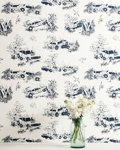 a vase filled with white flowers sitting on top of a table next to a wall