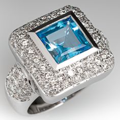 This captivating ring is centered with one (1), bezel set, square step cut natural topaz and is bordered with fifty-two (52), bead set, round brilliant cut diamonds. The shoulders of the ring are each accented with fourteen (14), bead set, round brilliant cut diamonds. The ring measures 16.7mm at the top, rises 7.2mm above the finger, tapering to 5.4mm wide and 1.7mm thick at the base of the shank. This ring is currently a size 6.5. Luxury Asscher Cut Diamond Topaz Ring, Luxury Asscher Cut Topaz Ring With Diamonds, Luxury Rectangular Topaz Anniversary Ring, Modern Topaz Ring With Diamond Accents, Formal Topaz Ring With Diamond Bezel Setting, Rectangular Diamond Topaz Ring For Anniversary, Rectangular Topaz And Diamond Ring For Anniversary, Luxury Topaz Ring With Bezel Setting For Anniversary, Luxury Topaz Anniversary Ring With Bezel Setting