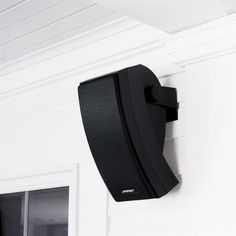 a black speaker mounted to the side of a wall