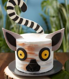 a cake decorated to look like a racoon with yellow eyes and black ears