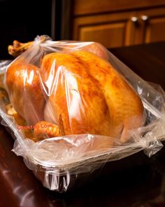 a turkey wrapped in plastic sitting on top of a table