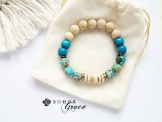 the bracelet is made with wood beads and turquoise glass bead, along with a tassel