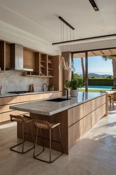 an open kitchen and dining area with large windows overlooking the pool in the back yard