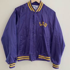 Louisiana State University Excellent Condition For This Vintage Jacket - Few Hard To Notice Blemishes Expected With Age But No Rips Or Tears Signature Satin Bomber Jacket With Purple And Gold Striped Wrists, Collar, And Waist Length: 24” Armpit To Armpit: 20” Collegiate Cotton Outerwear For Spring, Classic Purple Outerwear For Spring, Vintage Purple Outerwear For Spring, Classic Purple Spring Outerwear, Purple Cotton Outerwear With Pockets, Classic Purple Outerwear With Pockets, Casual Purple Varsity Jacket For Winter, Vintage Purple Cotton Outerwear, Casual Lavender Cotton Outerwear