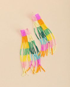 two pairs of multicolored beads with tassels hanging from each earring