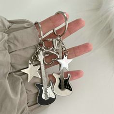 a person is holding two guitar key chains in their hand, one with a star on it