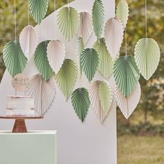 paper fans are hanging on the wall next to a cake