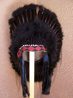 Discover the beauty and tradition of Native American culture with our Black Legend Warbonnet, carefully crafted by skilled Native American artisans. This stunning headpiece is a tribute to the traditional bonnets worn by Native Americans during the late 1800s and early 1900s. Embrace the rich history and spirit of this heritage piece. The bonnet has more than forty-eight black feathers sewn onto a heavy felt feather fluff-covered skull cap with a single honor feather in the center of the back. T Traditional Tall Crown Festival Headpieces, Traditional Tall Crown Headpiece For Festivals, Traditional High Crown Costume Hats For Festivals, Traditional Handmade Costume Hats And Headpieces, Traditional Handmade Costume Headpieces, Traditional Black Costume Hats And Headpieces For Festivals, Traditional Black Costume Hats For Festivals, Traditional Handmade Costume Hat With Round Crown, Traditional Adjustable Headpiece With Tall Crown