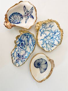 four seashells with blue and white designs on them