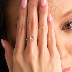 a close up of a person holding their hand to her face with the letter m on it