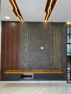 an empty room with some lights on the ceiling and a bench in front of it