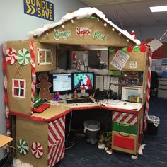 an office cubicle decorated for christmas with gingerbread house