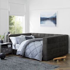 a grey couch sitting in a living room next to a window