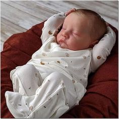 a newborn baby wrapped in a blanket sleeping