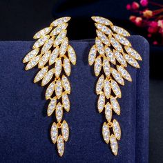 Elegant and classy, this pair of bridal earrings will add a touch of sophistication to any wedding gown or formal ensemble. The angel wing design is created to move in a fluid motion, while the flawlessly faceted cubic zirconia capture the light in a dazzling array of sparkles. The earrings are rhodium / yellow gold plated for a bright finish which enhances the intricate detailing and conveys a modern take on old elegance. Overall length of the earring is 2.5" (approx. 6.5cm). Available in Silve Dinner Gifts, Angel Wings Design, Wedding Earrings Drop, Angel Wing Earrings, Feather Wings, Fashion Boho, Cz Jewelry, Wing Earrings, Gold Filled Earrings