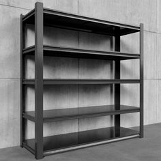 a black and white photo of an empty bookcase against a concrete wall with no one in it