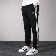 adidas originals Men's SST Track Pants in Black CW1275 (Casual/Stripe/Training) Spring Joggers With Side Stripes For Jogging, Spring Sweatpants With Side Stripes For Jogging, Sporty Joggers With Three Stripes And Relaxed Fit, Spring Sportswear Sweatpants With Side Stripes, Spring Sportswear Bottoms With Side Stripes, Casual Spring Joggers With Side Stripes, Sportswear Sweatpants With Three Stripes For Spring, Sporty Three Stripes Joggers For Spring, Sporty Spring Joggers With Three Stripes Branding