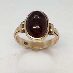 Antique American 14k Gold Victorian Garnet Ring Hallmarked 3.8 Gram Size 6.75 This antique Victorian ring is a true gem. Crafted from 14K yellow gold, it features a beautiful oval-shaped garnet stone that glows a natural brown color. The ring is hallmarked and weighs 3.8 grams, making it a perfect size 6.75. Its bezel setting style and cocktail style make it a versatile piece for any occasion, whether it's an anniversary, birthday, or Valentine's Day. The ring is unisex and has a natural theme. It was made in the United States and is acid-tested for purity. This piece is perfect for anyone who loves vintage and antique jewelry. Hallmarked Acid tested 14K 1/2 inch wide on top Formal Fine Jewelry Signet Ring With Cabochon, Formal Cabochon Signet Ring, Classic Yellow Gold Sapphire Ring Oval Cabochon, Formal 14k Gold Sapphire Ring With Oval Cabochon, Classic Yellow Gold Signet Ring With Cabochon, Classic Oval Cabochon Rings Stamped 14k, Classic Cabochon Sapphire Ring For Formal Occasions, Classic Gold Opal Gemstone Ring, Classic Formal Cabochon Sapphire Ring