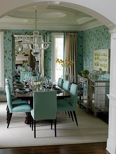 a dining room with blue chairs and green walls