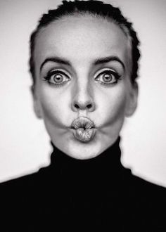 a black and white photo of a woman making a face with her tongue sticking out