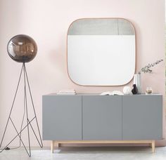 a grey cabinet and mirror in a pink room