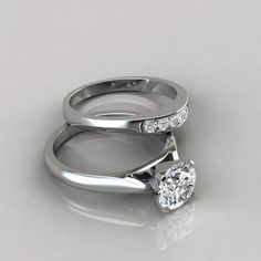 two white gold wedding rings with diamonds on each one and the other side, set against a gray background