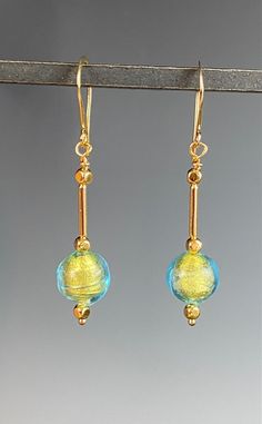 "Cast your eyes on these beautiful artisan glass beads created in Murano, Italy! These 10mm glass beads have a subtle light blue cast with shiny genuine 14k gold foil within them. They hang 2 inches on gold Vermeil ear wires. These are actually vintage glass beads from the 1970's! These earrings are so fun as they move and swing with a high luxury look and feel! The neutral color of these earrings will allow you to wear them with any outfit. A wonderful gift for any occasion and arrives in a sta Murano Glass Earrings, Murano Glass Necklaces, Murano Glass Jewelry, Jewelry Holiday, Murano Italy, Holiday Earrings, Gold Moon, Holiday Earring, Venetian Glass