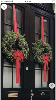 two christmas wreaths are hanging on the front door