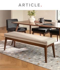 a dining room table with two chairs and a bench in front of it on a rug