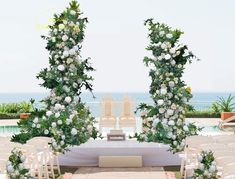 an outdoor ceremony setup with white flowers and greenery