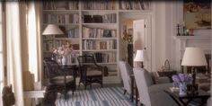 a living room filled with furniture and bookshelves covered in lots of bookcases