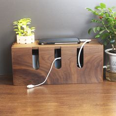 an electronic device is plugged in to a wooden box with plants on the side