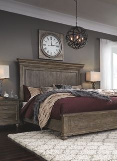 a bedroom with a bed, dresser and clock on the wall next to it's windows