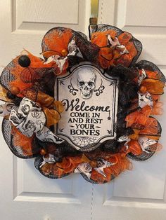 a welcome sign is attached to the front door with mesh netting and skulls on it