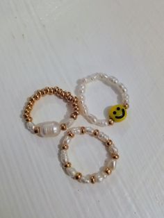 Freshwater pearl stretch bead rings. Three different styles. Freshwater pearls and smiley face. Freshwater pearls and gold glass seed beads. Large  Freshwater pearl and gold glass seed beads  Stretchy.  Sizes  5/6/7  cms. S/M/L Made using strong 5mm crystal stretch elastic. Super cute and ideal to wear on its own or as stacking rings. Trendy Inelastic Round Beaded Jewelry, Cute Pearl Jewelry With Colorful Beads, Trendy Round Pearl Jewelry, Trendy Round Pearl Bead Jewelry, Trendy Pearl Jewelry With Round Beads, White Beaded Pearl Ring, Adjustable Trendy Pearl White Jewelry, Trendy White Beaded Rings, Trendy Pearl White Beaded Jewelry