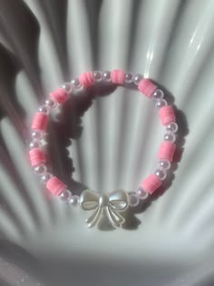 a pink and white bracelet with a bow on it