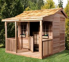 a wooden shed sitting on top of a lush green field