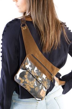 a woman wearing a brown and black floral print cross body bag with her back to the camera