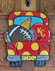 a door hanger with a football and helmet painted on it's front side