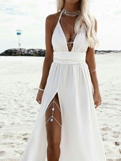 a woman wearing a white dress on the beach