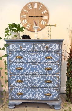 a blue and white painted dresser next to a clock