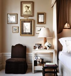 a living room filled with furniture and framed pictures on the wall next to a window