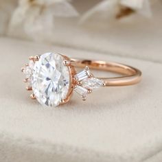 a rose gold engagement ring with an oval cut diamond surrounded by three baguettes