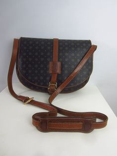 Vtg Pollini Saddlebag Black Brown Signature Leather Shoulder Crossbody Italy Equestrian Black, Brown  Leather Brass Hardware Inner Back Zip Pocket Vinyl Lined Adjustable Strap Front Magnetic Snap Closure Height  8.5" Width 11" Depth   3.5" Strap Drop  23.5" (adjustable) "good vintage condition - some wear on strap" Vintage Crossbody Bag With Gold-tone Hardware, Vintage Saddle Bag With Detachable Strap For Daily Use, Vintage Brown Saddle Bag With Detachable Strap, Vintage Saddle Bag With Detachable Strap, Vintage Saddle Shoulder Bag With Detachable Strap, Vintage Saddle Bag With Detachable Strap For Travel, Vintage Leather Saddle Bag With Gold-tone Hardware, Vintage Crossbody Saddle Bag For Business, Vintage Brown Saddle Bag For Formal Occasions