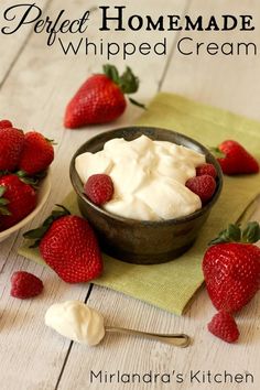 a bowl of whipped cream with strawberries on the side